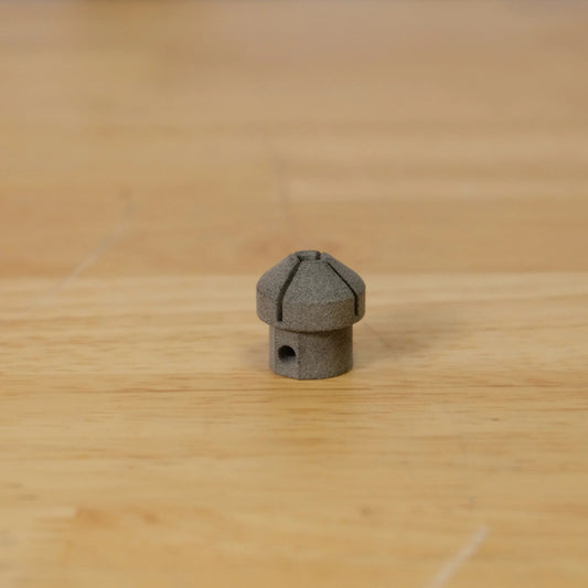Small grey metal object on a wooden surface